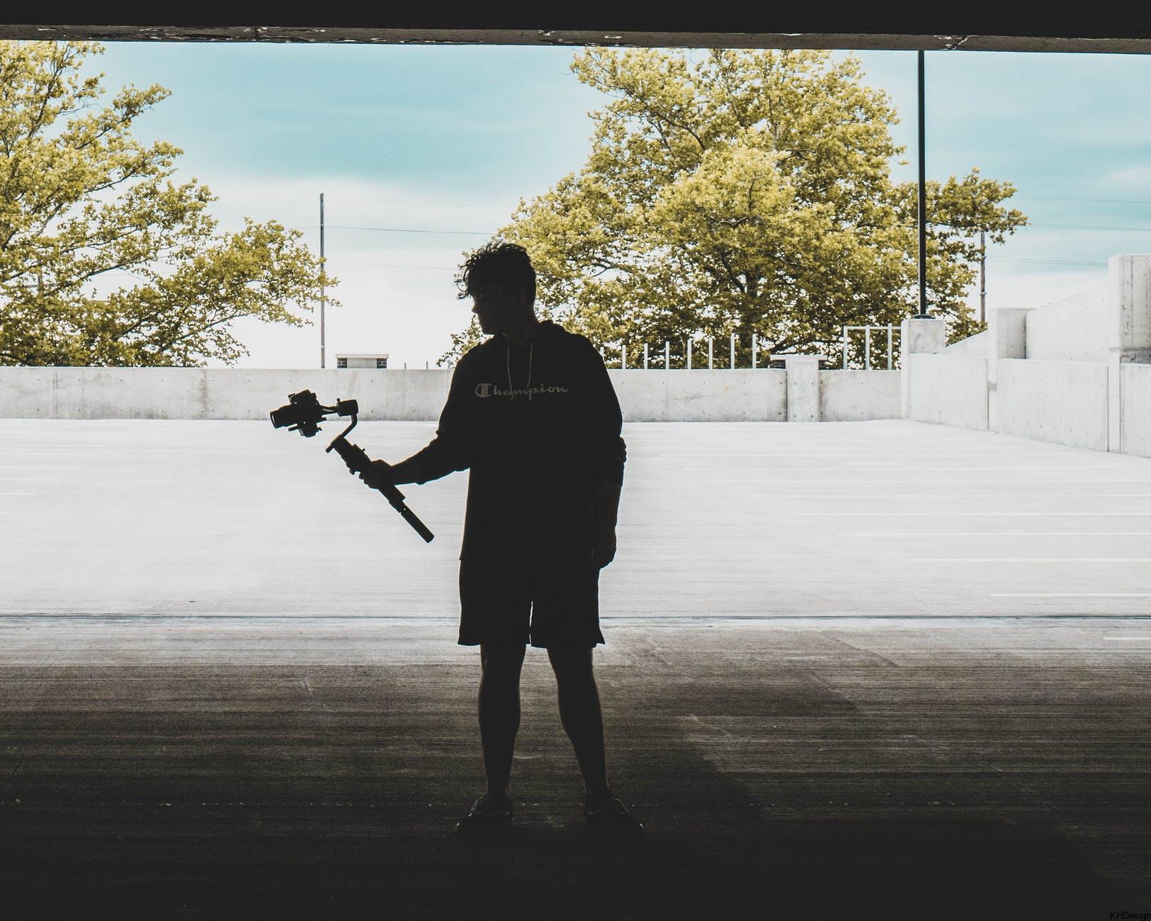 silhouette of a man carrying a camera